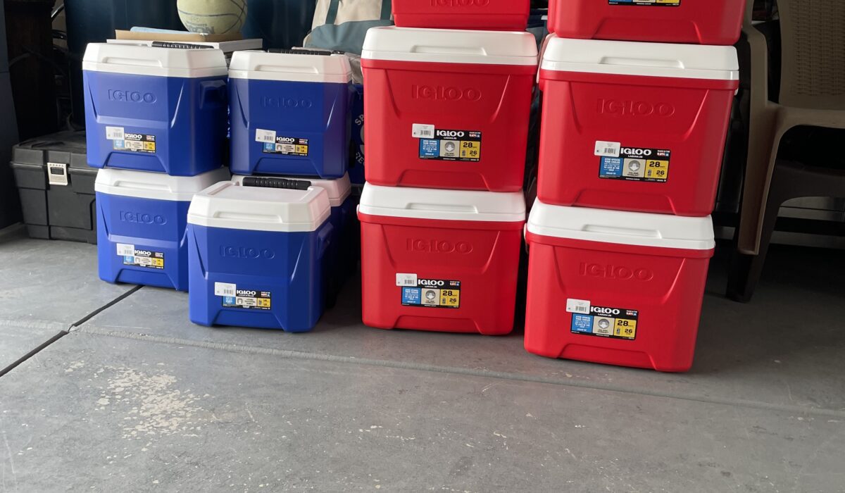 A bunch of red and blue boxes kept together in front of barrels